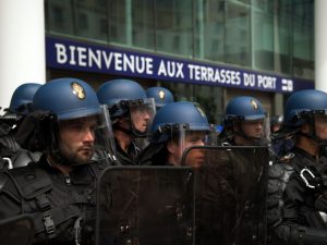 Anti-riot gendarmes protect the entrance of Les Terrasses du Port commercial centre during a demonstration against the French government's planned labour law reforms on May 26, 2016 in Marseille. The French government's labour market proposals, which are designed to make it easier for companies to hire and fire, have sparked a series of nationwide protests and strikes over the past three months. / AFP PHOTO / BERTRAND LANGLOIS